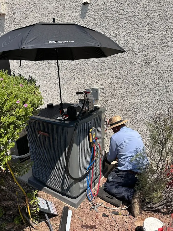 HVAC technician performing outdoor AC maintenance in Kennebunk